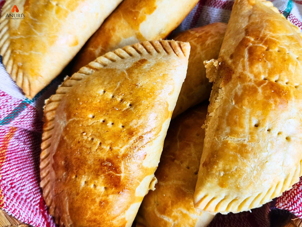 A well-baked golden brown meat pie with a flaky crust, served on a plate and ready to eat.