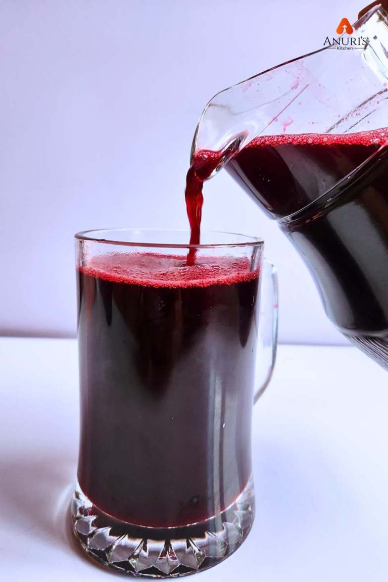Zobo drink in a cup with more being poured into it.
